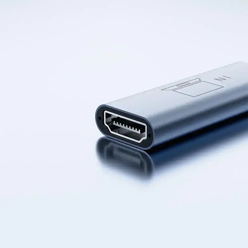 Close-up of a sleek HDMI adapter on a reflective surface, tech accessory for monitors TUTT