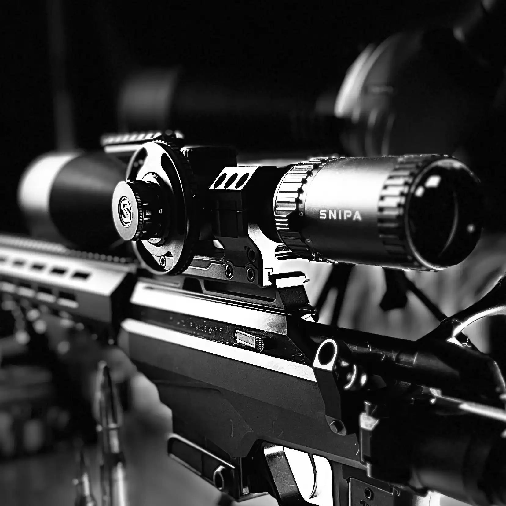Close-up of SNIPA POLAR X tactical rifle scope mounted on rifle, black and white. TUTT