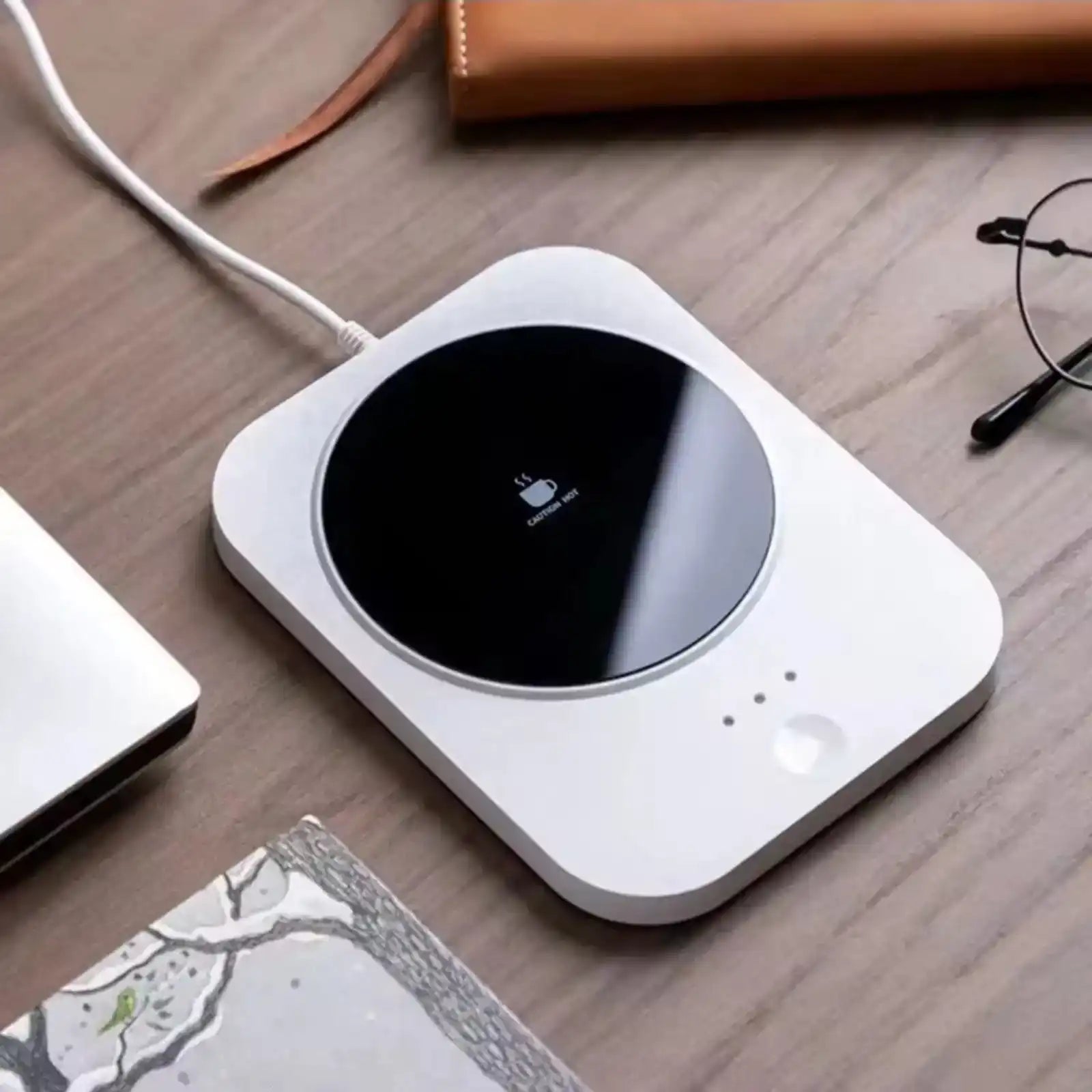 USB coffee warmer with digital display on wooden desk, glasses and notebook nearby TUTT