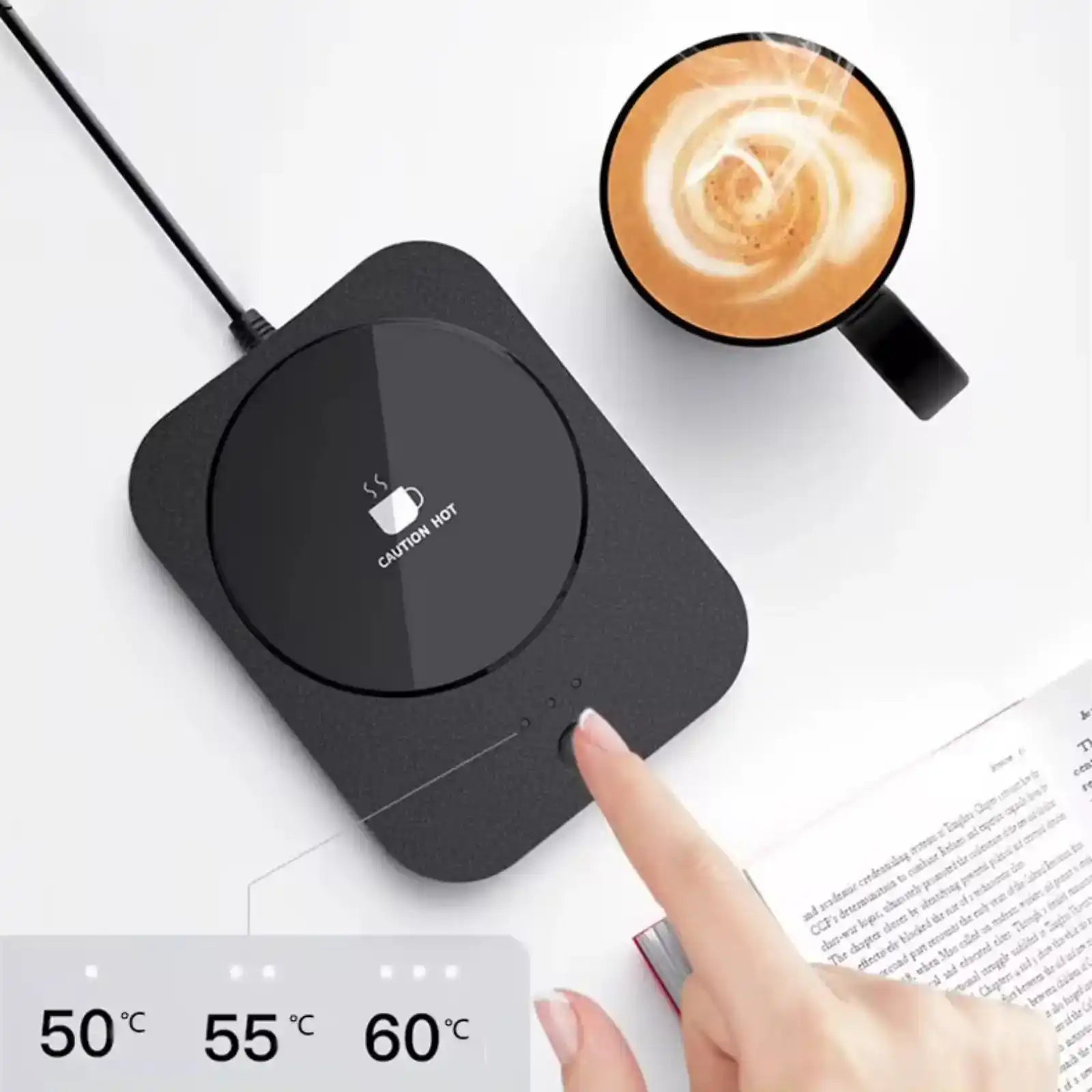 USB coffee warmer with temperature settings, cup of coffee, and open book on white desk TUTT