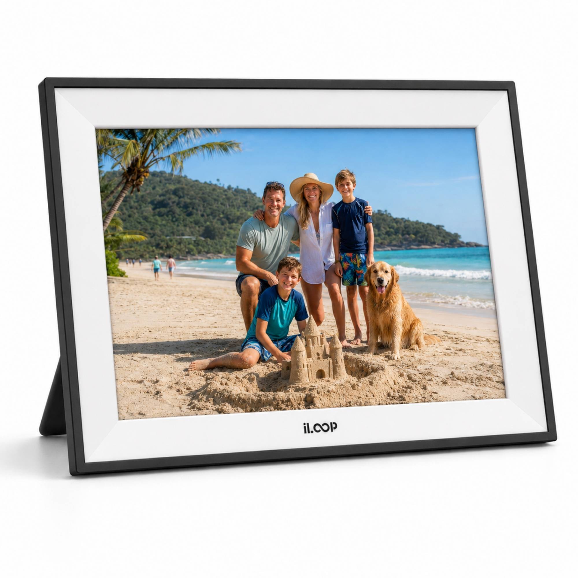A black rectangular digital photo frame with a white mat and a small kickstand, shown on a white background. The screen displays a family beach photo with a dog.