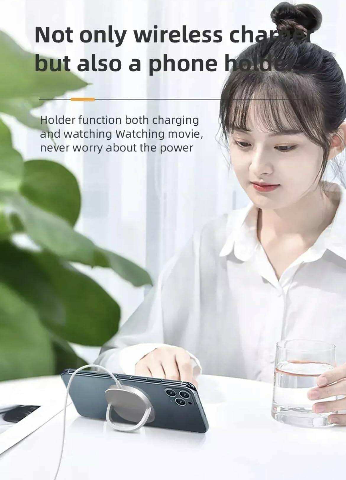 Woman using magnetic wireless charging pad with smartphone stand on table, holding glass, TUTT