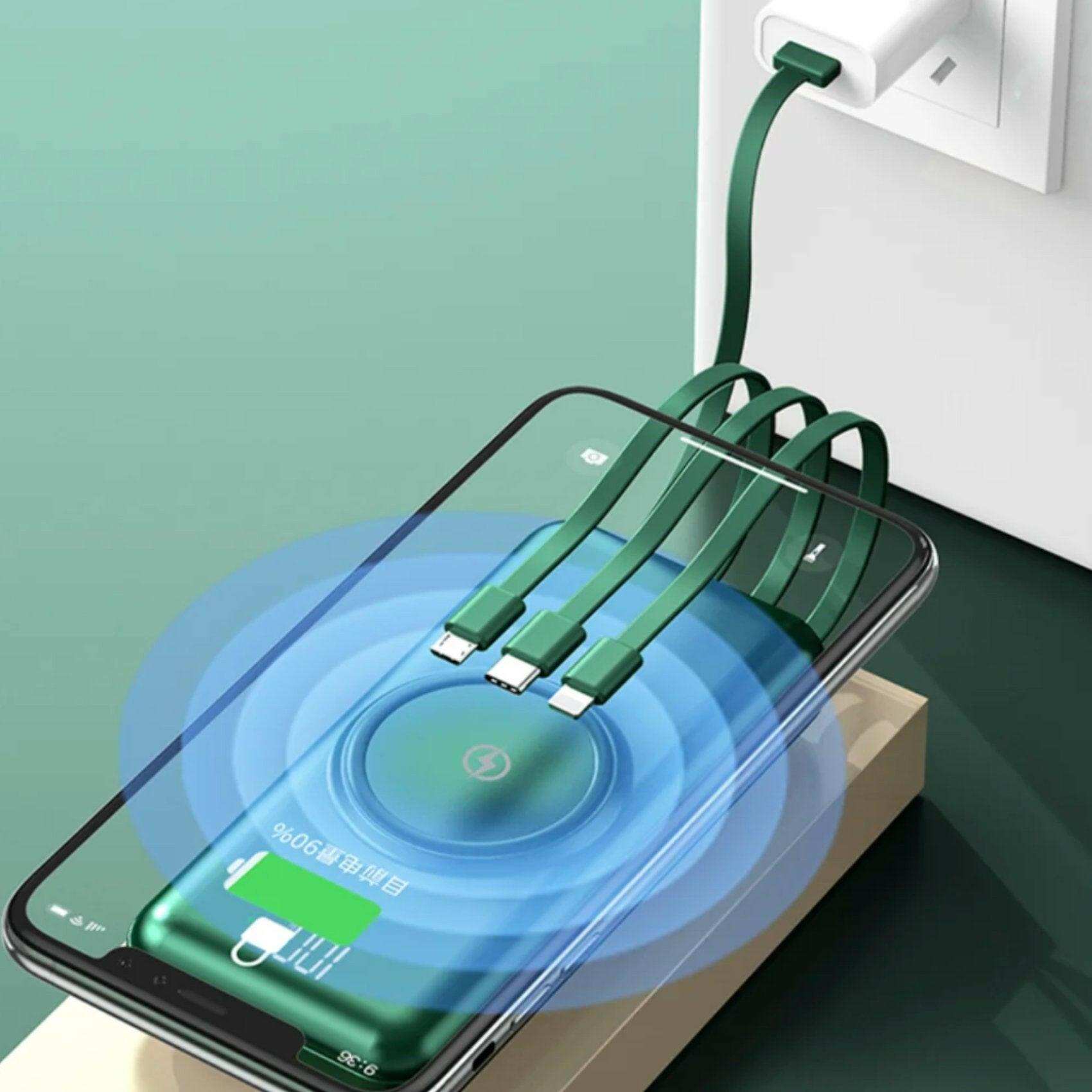 Green 30000mAh wireless portable charger power bank with built-in cables charging a phone, LED display visible, fast charging, on green surface. TUTT