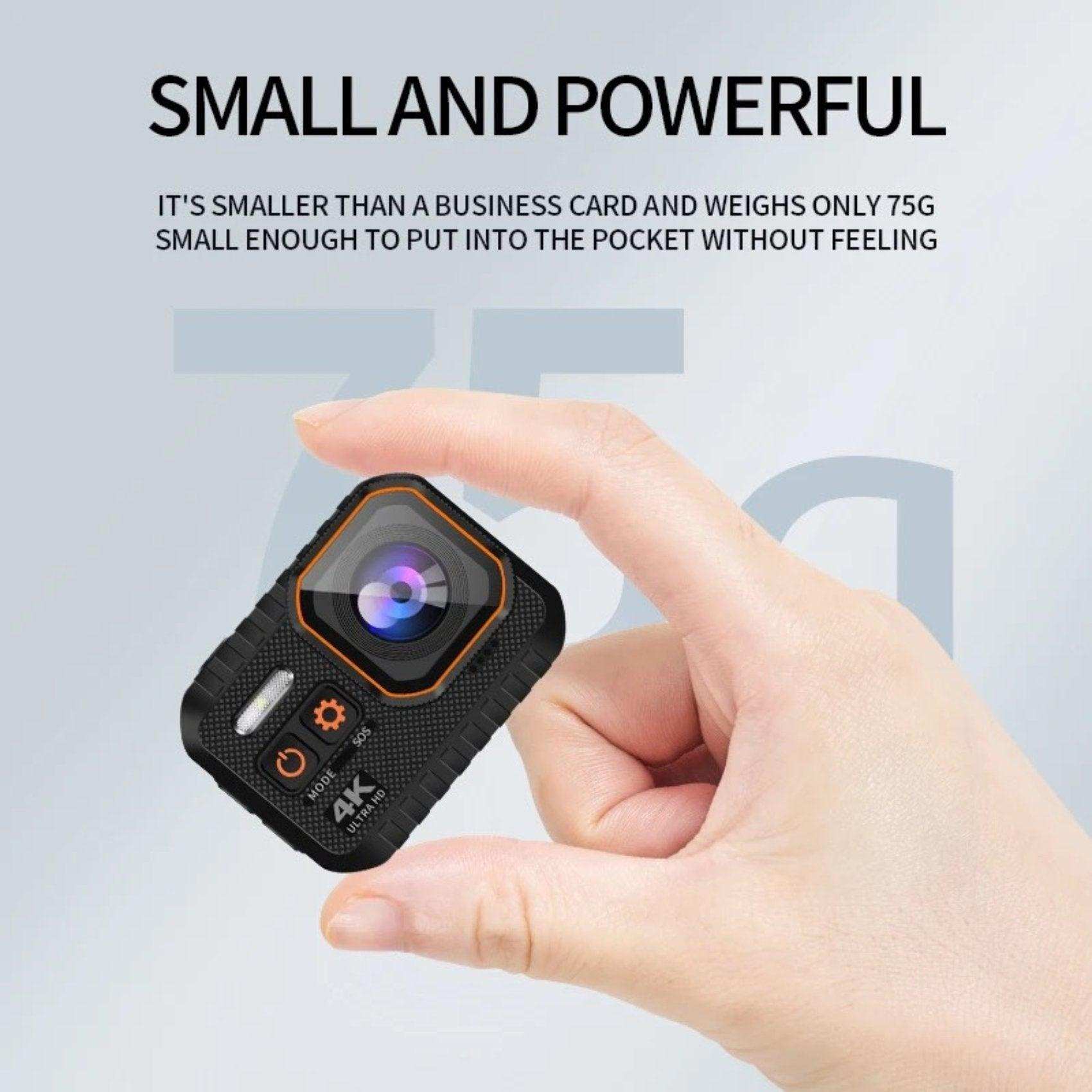 Hand holding compact 4K waterproof action camera with orange trim, close-up on lens, TUTT