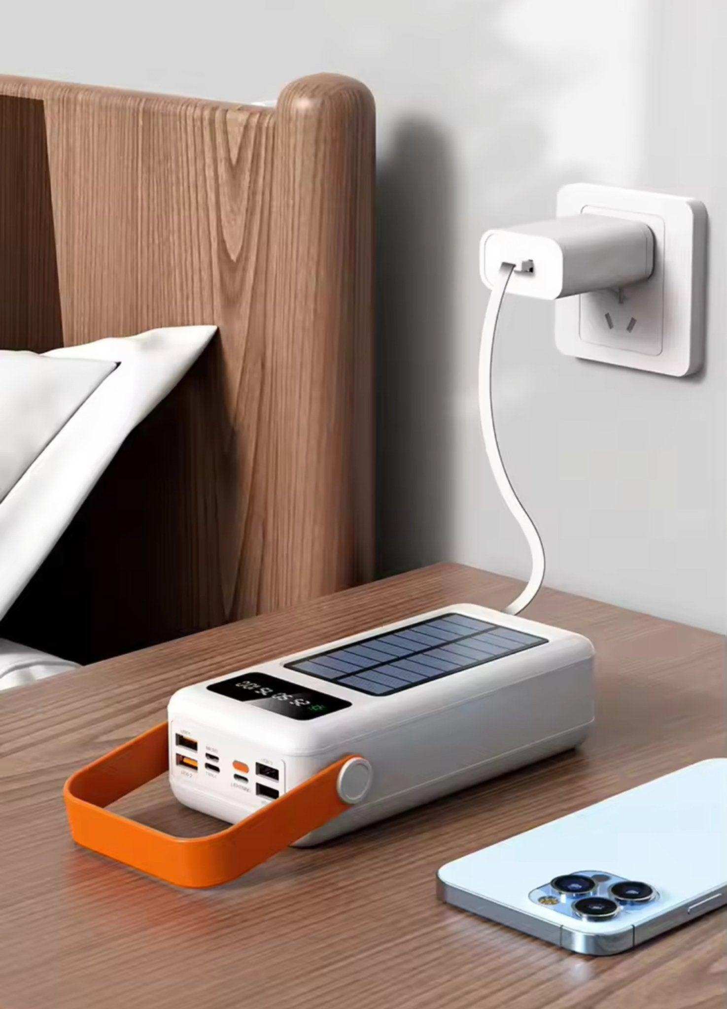 60000mAh solar power bank with fast charging, built-in cables, orange handle, on bedside table, TUTT