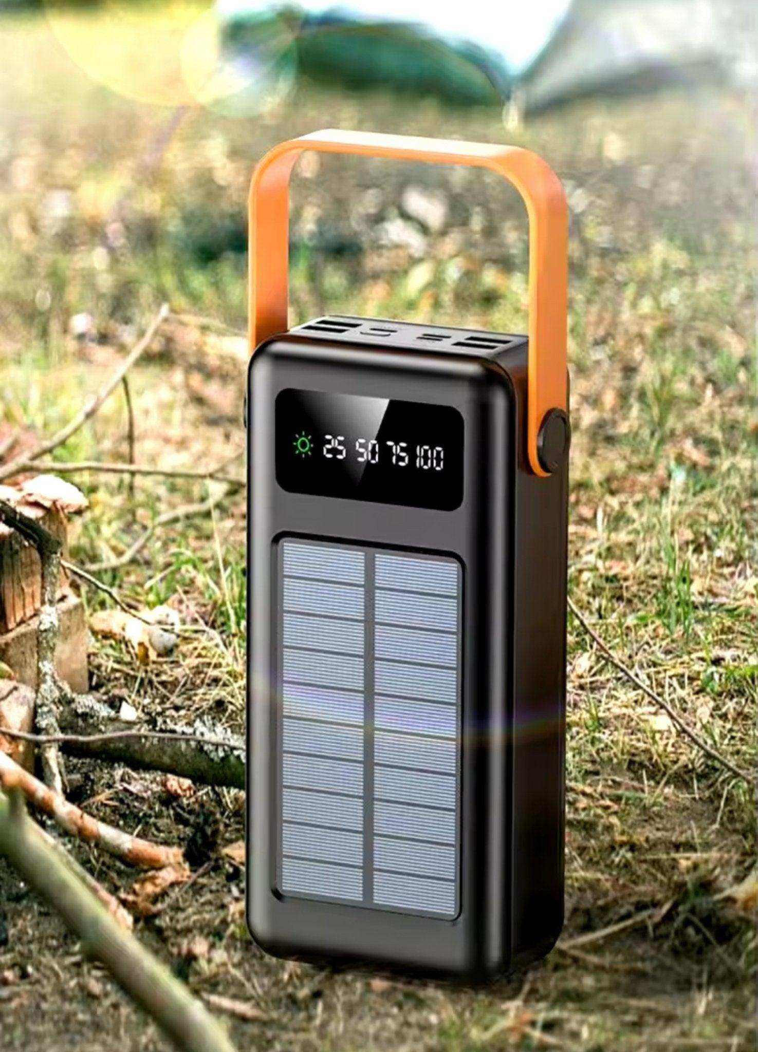 Large black solar power bank with digital display and orange handle outdoors, portable charger TUTT