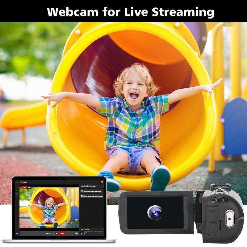 Child sliding down yellow playground slide, camcorder and laptop livestream setup, TUTT