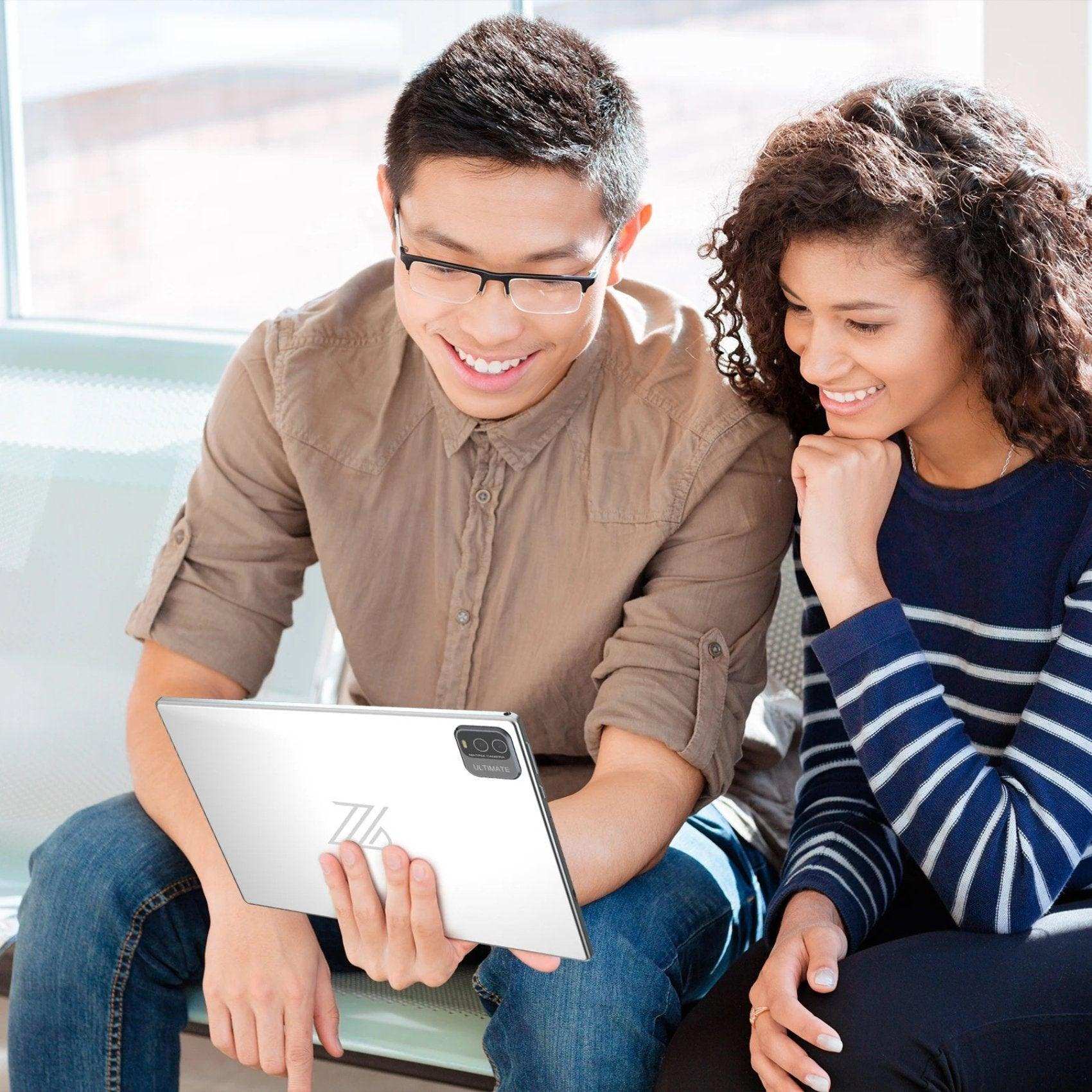 Two people smiling while using a white 10.1 inch TUTT 2-in-1 Android tablet. TUTT