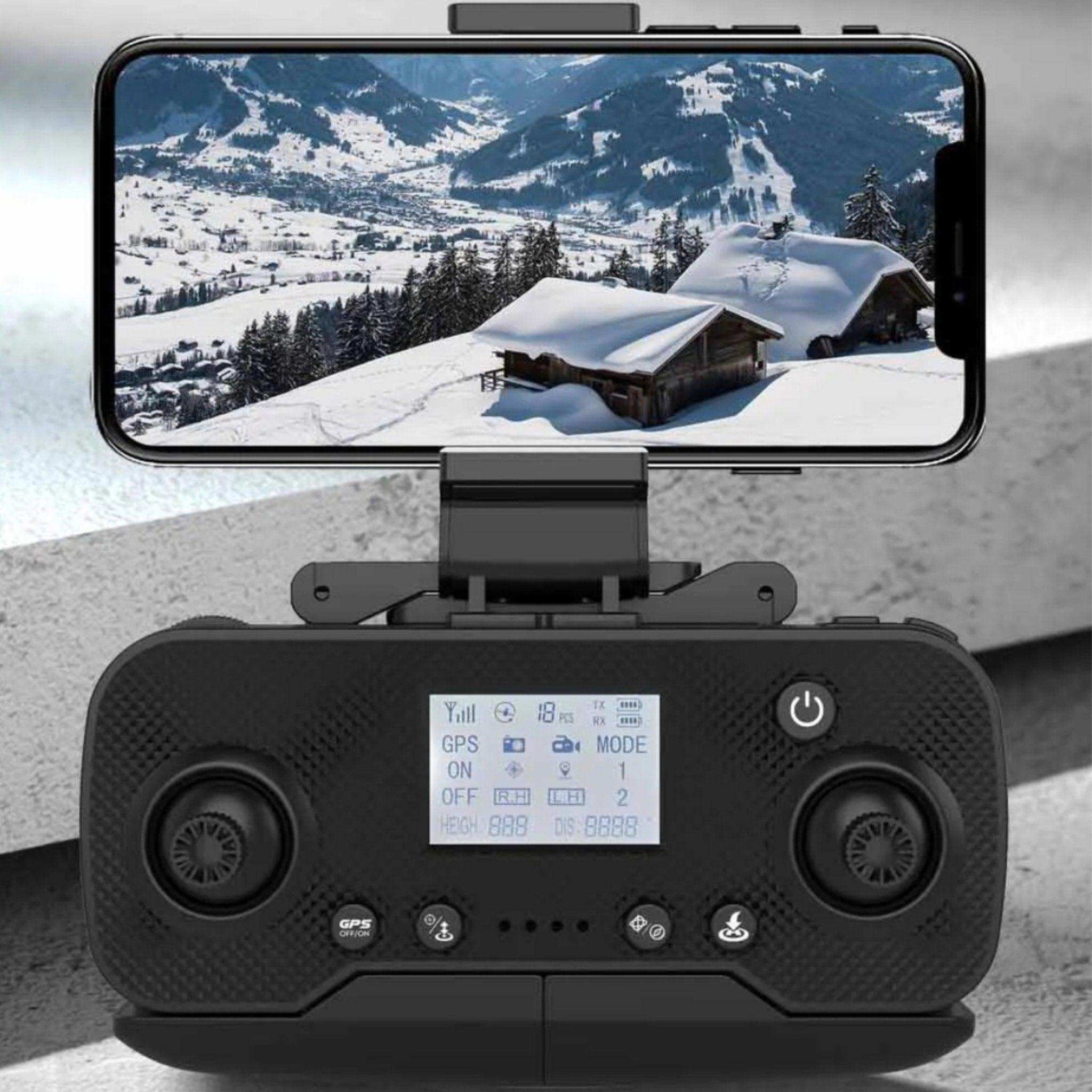 TUTT KF110 drone controller with smartphone display showing snowy mountain cabin scene TUTT