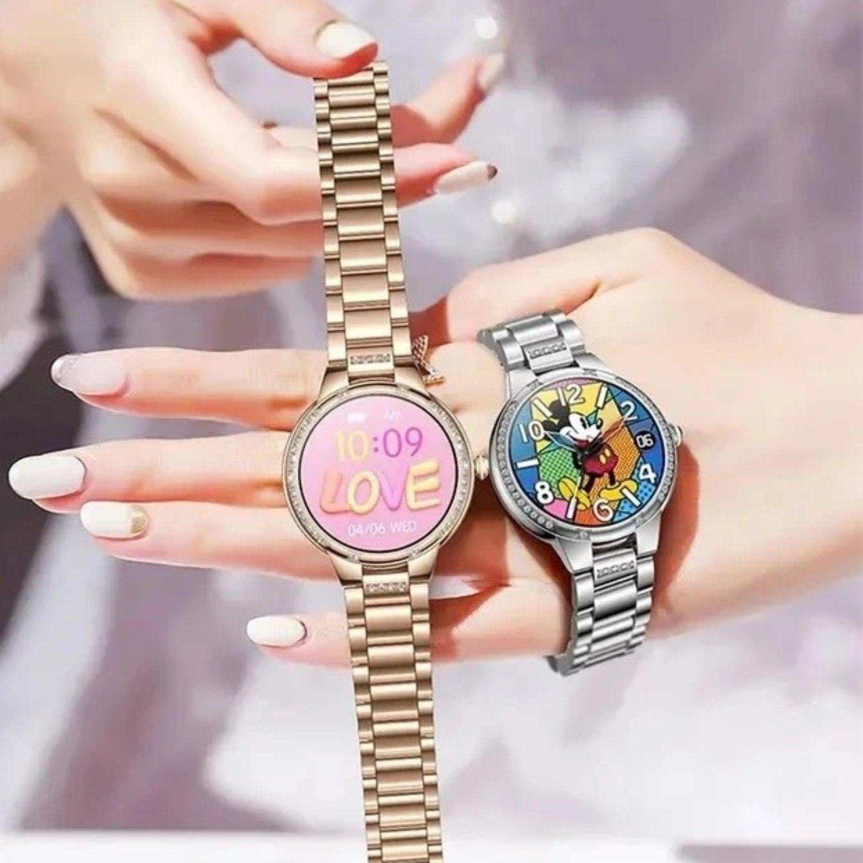 Two women's smart watches with AMOLED screens, gold and silver bands, vibrant dials, on a hand, TUTT