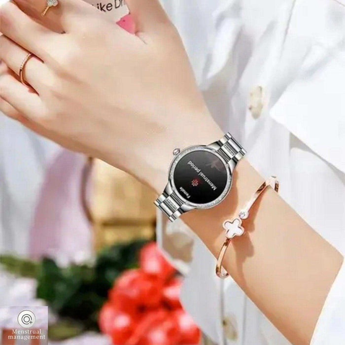 Silver ladies AMOLED screen smart watch showing menstrual period tracker on wrist, TUTT