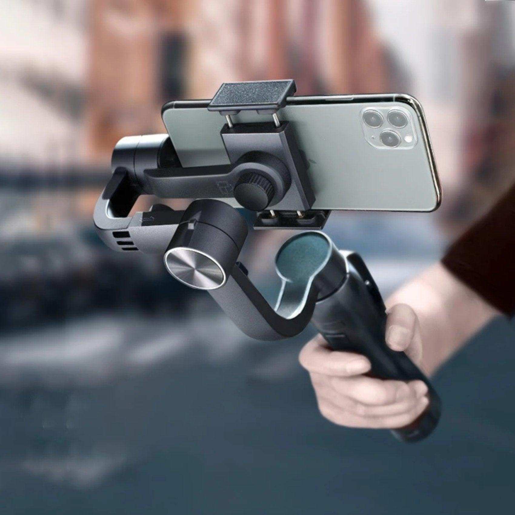 Hand holding 3-axis gimbal stabilizer with smartphone, anti-shake tripod, street background TUTT