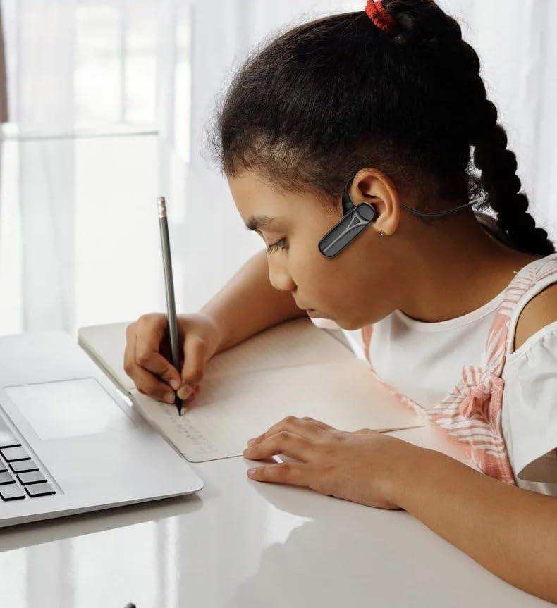 Girl wearing Bluetooth bone conduction headphones, writing in notebook beside laptop, TUTT