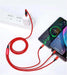 Red 3-in-1 charging cable connected to power strip and three smartphones charging, TUTT